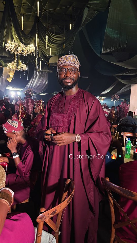 A customer in burgundy agbada wearing his Astral Date Master at an owambe