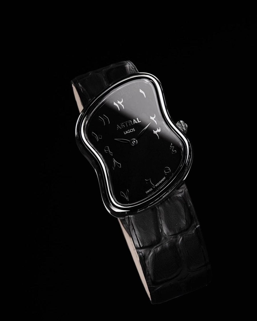 Astral Retro in silver with a black dial and black croc strap, floating against darkness